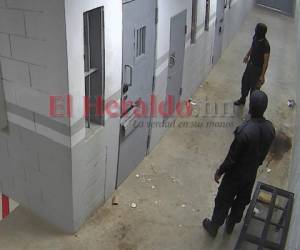 Dos Policías Penitenciarios llegan a las celdas e los privados de libertad para sacar las panas donde les entregaron sus comidas.