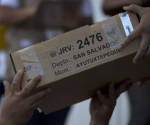 Un voluntario recibe una caja con boletas electorales en una casilla a las afueras de San Salvador, El Salvador, el viernes 1 de febrero de 2019. (AP Foto/Moises Castillo)