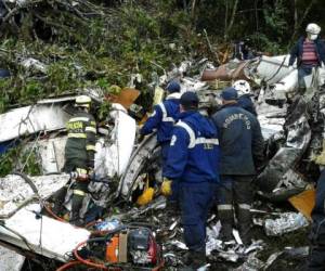 Varios cuerpos de rescate de Colombia trabajaron para sacar los cuerpos del avión de debajo de los escombros. Foto: AP