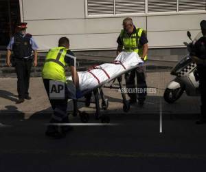 Operarios sacan un cadaver en una camilla, en el exterior de una comisaría de policía tras un ataque en Cornella de Llobregat, cerca de Barcelona. (Foto: AP)