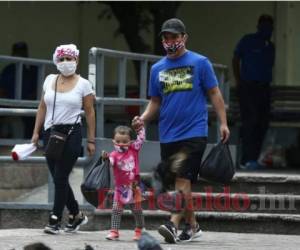 Esta familia camina con las medidas de bioseguridad por el Parque Central de Tegucigalpa. Fotos: EL HERALDO.