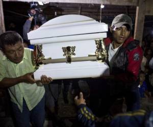 Vecinos cargan el ataúd que contiene el cuerpo de Jakelin Caal Maquin, de 7 años, dentro de casa de sus abuelos en San Antonio Secortez, Guatemala. Foto: AP