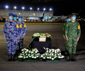 Las urnas, cuidadosamente empaquetadas, fueron bajadas del avión y colocadas en una mesa con flores blancas y custodiada por militares la medianoche del sábado. AFP.