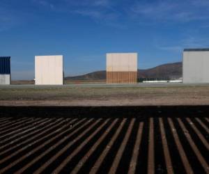 Estos son los prototipos de muro fronterizo que están en San Diego cerca de la frontera de México con Estados Unidos, vistos desde Tijuana, México, enfrente de la sombra del actual muro. (AP Foto/Moisés Castillo, Archivo)