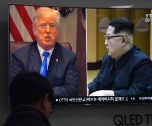 Donald Trump y Kim Jong-Un en una pantalla de televisión. (AFP)