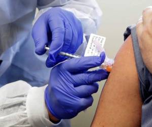 En esta fotografía del 16 de marzo de 2020, una persona es inyectada en la primera etapa de un ensayo clínico para una posible vacuna contra el covid-19.