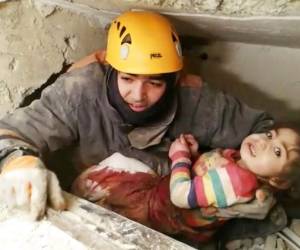 Un rescatista saca a una niña de las ruinas de un edificio colapsado por un terremoto en Elazig, Turquía el sábado tras el sismo. Foto: AP.