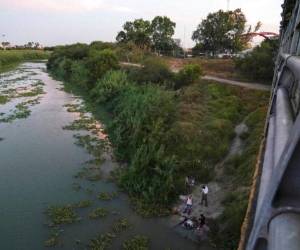 En esta fotografía del 30 de agosto de 2019, unos solicitantes de asilo lavan su ropa en el río Bravo, cerca del puente internacional Gateway, en Matamoros, México. Foto: AP