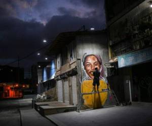 En esta foto del 2 de enero de 2021, el artista callejero Wolfgang Salazar trabaja en una mural de la atleta venezolana Yulimar Rojas en el barrio de Boleita, en Caracas. Foto: AP