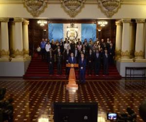 El presidente guatemalteco Jimmy Morales, flanqueado por el vicepresidente Jafeth Cabrera (delantero-R) y su gabinete, hace una declaración en el Palacio de la Cultura en la Ciudad de Guatemala el 7 de enero de 2019. / AFP / NOÉ PÉREZ.