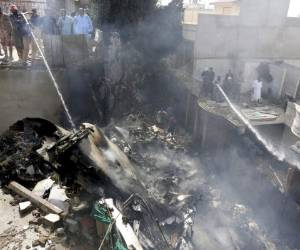 Soldados y voluntarios ayudan en las labores de emergencia en el sitio donde se estrelló un avión de pasajeros en Karachi, Pakistán. Foto AP