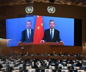 El ministro de Relaciones Exteriores de China, Wang Yi, aparece en una pantalla mientras pronuncia un discurso remoto en la apertura de una sesión del Consejo de Derechos Humanos de la ONU, luego de la invasión rusa en Ucrania, en Ginebra, el 28 de febrero de 2022.