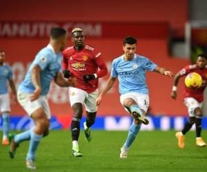 El mediocampista español del Manchester City, Rodri, pasa el balón durante el partido de fútbol de la Premier League inglesa entre el Manchester United y el Manchester City en Old Trafford en Manchester.