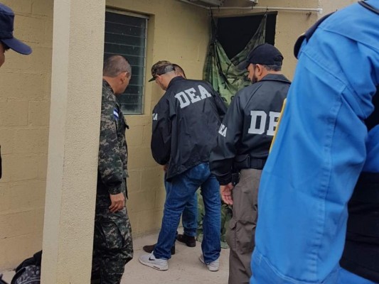Los agentes de la DEA esposan al presunto narcotraficante hondureño para subirlo a la avioneta que los trasladará hacia Estados Unidos.