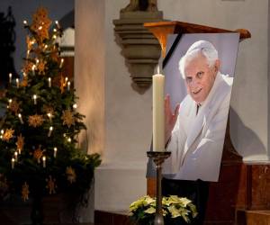 Una fotografía del papa emérito Benedicto XVI se ve durante una oración en la Iglesia Catedral de Nuestra Señora (Frauenkirche) el 31 de diciembre de 2022 en Munich, Alemania. El papa Emérito Benedicto XVI, un teólogo alemán cuya renuncia en 2013 tomó al mundo por sorpresa, murió el 31 de diciembre de 2022 a la edad de 95 años, anunció el Vaticano.