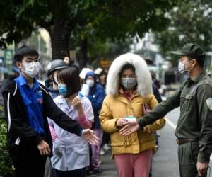 El costo humano del brote de coronavirus sigue aumentando en China y más allá de sus fronteras. Foto AFP