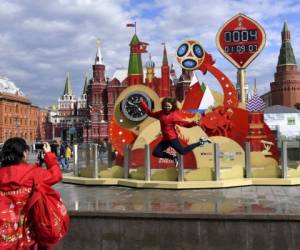 Una voluntaria salta para fotografiarse en el reloj que lleva el conteo regresivo para que inicie la FIFA World Cup de este 2018. (Foto: AFP)