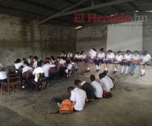 Por falta de aulas y de mobiliario, los alumnos reciben sus clases en el suelo de un salón de usos múltiples.