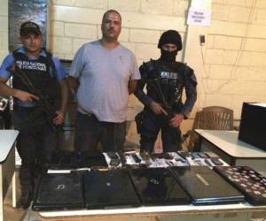 Miembros de la DPI muestran al acusado con las cosas que se le decomisaron.