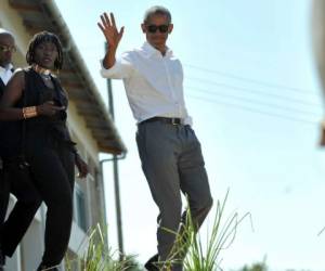 El ex presidente de los EE.UU., Barak Obama, saluda mientras camina con su media hermana, Auma. Foto AFP