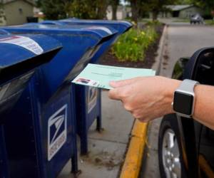 En esta imagen de archivo, tomada el 18 de agosto de 2020, una persona deposita un sobre solicitando el voto por correo en un buzón, en Omaha, Nebraska.