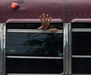 Los reos sacaban sus manos a través de las ventanas de los buses en los que serían trasladados a varias cárceles de Honduras. Foto: Agencia AFP