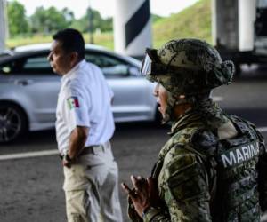 A Mexican migration agent stops minibuses and taxis in search of undocumented migrants at a checkpoint on the outskirts of Tapachula, Chiapas State, on June 10, 2019 in the framework of Mexico's deal to curb migration in order to avert US President Donald Trump's threat of tariffs. - Mexico said Monday it will discuss a 'safe third country' agreement with the United States -- in which migrants entering Mexican territory must apply for asylum there rather than in the US -- if the flow of undocumented immigrants continues. (Photo by Pedro PARDO / AFP)