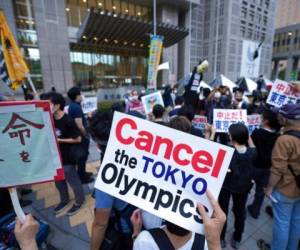 En esta imagen del 23 de junio de 2021, personas se manifiestan en contra de los Juegos Olímpicos de Tokio a las afueras de un edificio del gobierno metropolitano de Tokio. FOTO: AP