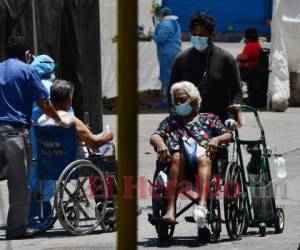 Un paciente de covid-19 es trasladado a una de las cuatro carpas instaladas para tratar casos, en el estacionamiento del Hospital Escuela de Tegucigalpa. Foto: AFP.
