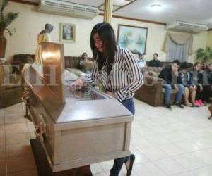 Los restos mortales de Luis Joel Rivera Perdomo fueron velados en Funerales Jerusalén, en la capital de Honduras. Una doliente llora sobre el ataúd su violenta partida. Foto EL HERALDO