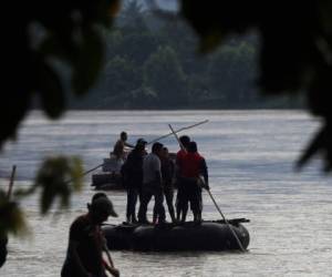 Los migrantes centroamericanos se paran en una balsa cuando cruzan el río Suchiate, uniendo México y Guatemala, como se ve desde cerca de Ciudad Hidalgo, México. Foto: Agencia AP.