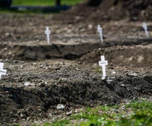 La ciudad de Milán, en el corazón de Lombardía, la región italiana más afectada por el coronavirus, comenzó este jueves a enterrar decenas de cuerpos no reclamados de víctimas de la pandemia. Hileras de pequeñas cruces blancas han sido alineadas frente a la sepultura excavada por un tractor. Todas llevarán el nombre del fallecido y las fechas de nacimiento y muerte. Fotos: Agencia AFP.