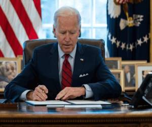 El presidente Joe Biden firma órdenes ejecutivas para que más gente cuente con seguro médico, en la Oficina Oval de la Casa Blanca, en Washington el 28 de enero de 2021. (AP Foto/Evan Vucci).