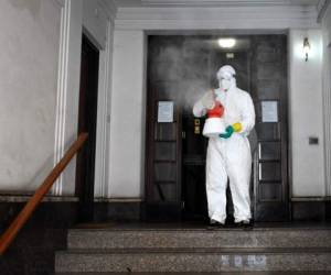 An employee of a private company sprays disinfectant in a building on March 31, 2020 in Rome, during the country's lockdown aimed at stopping the spread of the COVID-19 (new coronavirus) pandemic. (Photo by Alberto PIZZOLI / AFP)
