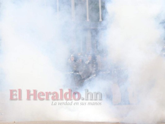 El humo de las bombas lacrimógenas cubre una gran parte en la entrada de la Universidad Nacional Autónoma de Honduras (UNAH). Foto: Alex Pérez/EL HERALDO.