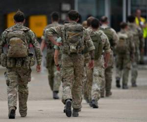 Miembros de la 16a Brigada de Asalto Aéreo de las fuerzas armadas británicas caminan hacia la terminal aérea después de desembarcar de un avión Royal Airforce Voyager en Brize Norton, Oxfordshire, el 28 de agosto de 2021, mientras las tropas regresan de ayudar con la evacuación de personas del aeropuerto de Kabul en Afganistán. El Reino Unido está terminando su operación de transporte aéreo de civiles antes de la fecha límite del 31 de agosto para la retirada de las tropas estadounidenses, mientras las fuerzas talibanes se preparan para apoderarse del aeropuerto. Foto: AFP