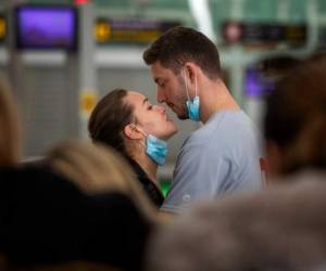 Una pareja se besa en el aeropuerto de Barcelona, España, el 12 de marzo de 2020. AP.