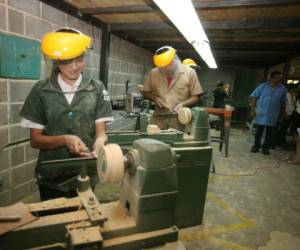 Estos jóvenes aprenden a elaborar la base para una lámpara en la clase de carpintería en el Técnico Luis Bográn. Foto: Efraín Salgado.