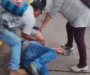 Momento en el que el comunicador cayó al suelo tras el golpe que le dio el guardia de seguridad.