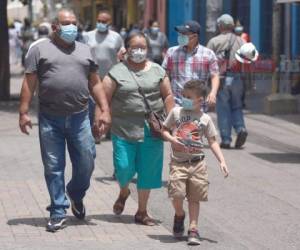 Este par de abuelitos caminan por el Parque Central junto a su nieto. Foto: Emilio Flores | EL HERALDO