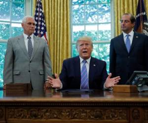 El presidente Donald Trump durante una ceremonia en la Oficina Oval, acompañado del vicepresidente Mike Pence, a la izquierda, y el secretario de Salud y Servicios Humanos, Alex Azar, el lunes 1 de julio de 2019, en Washington.
