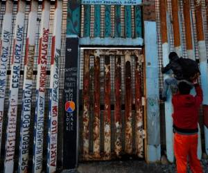Los migrantes saltan el muro y esperan a que los agentes de ICE los detenga. Foto: Agencia AP