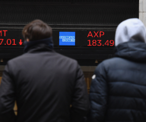 La gente mira las acciones que se muestran en la Bolsa de Valores de Nueva York en Wall Street el 24 de febrero de 2022 en Nueva York.