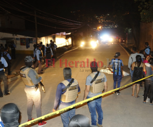 Vecinos observan consternados la escena con varios cuerpo sobre la calle, mientras las autoridades acordonan el área.