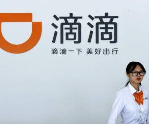 In this June 13, 2016, photo, a receptionist walks by front desk of the service station for Didi Chuxing's drivers in Hangzhou in east China's Zhejiang province. Chinese ride-hailing giant Didi Chuxing has fired two executives and will suspend one of its carpooling services nationwide starting Monday after a woman was allegedly raped and killed by a driver in eastern China, the company said Sunday, Aug. 26, 2018. (Chinatopix via AP)