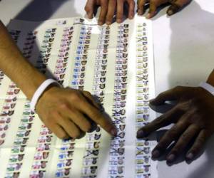 Funcionarios electorales salvadoreños trabajan en una mesa electoral durante las elecciones legislativas y municipales en San Salvador. Foto AFP