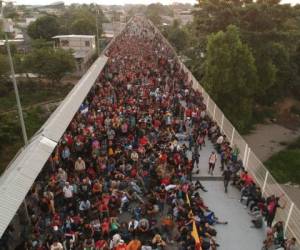 Una avanzadilla llegó hasta la verja de hierro que pone 'Bienvenidos a México' y que se mantenía cerrada, para entregar un documento. 'Señor presidente, lo que queremos es Trabajar'. Foto: AFP.