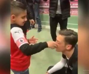 El pequeño, no vidente, toca el rostro de Mesut Özil para reconocerlo.