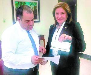 El secretario de la PGR, Robero Meza, recibe el escrito y el cheque de parte de Gladis Aurora López, presidenta del Partido Nacional.