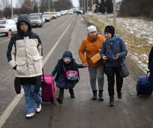 Con solo dos maletas en mano, esta familia camina en busca de refugió hacia la frontera de Polonia.